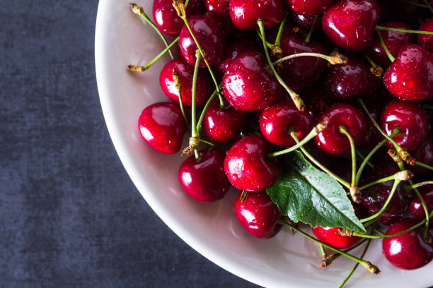 istock Fresh red ripe cherries on white plate 956051724