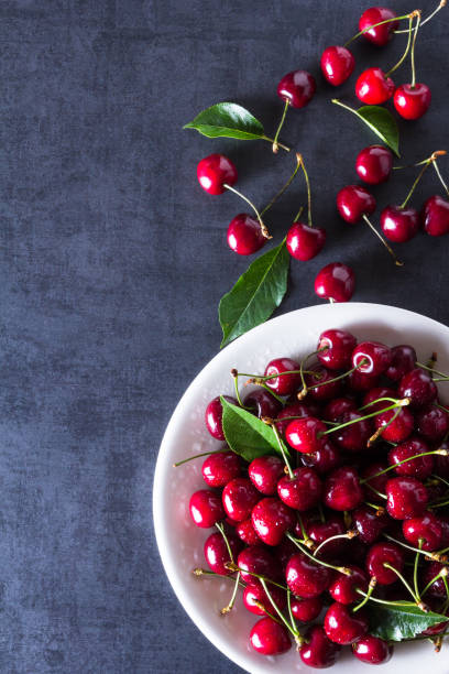 istock Fresh red ripe cherries on white plate 956053280