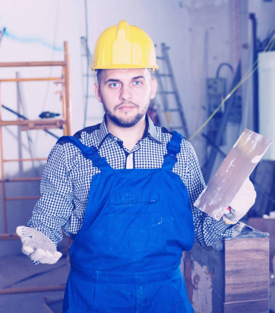 istock Workman in the helmet is ready to plastering the wall 956057020