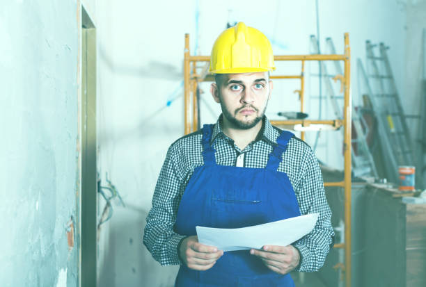 istock Plasterer is looking on the project of work for the object. 956057092