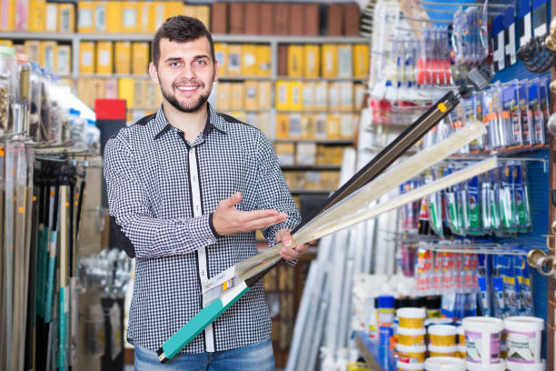 istock smiling male customer examining moldings in houseware store 956060704