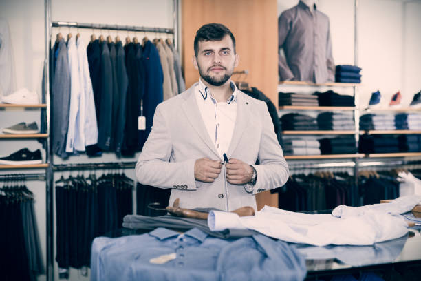 istock Smiling young male customer choosing new jacket 956060816