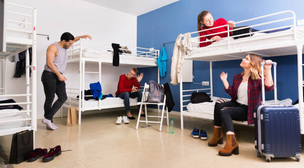 istock Young men and women friendly interacting while staying in modern comfy hostel 956062260