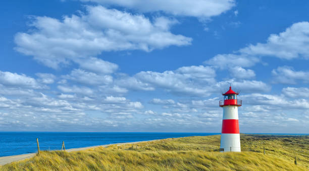 istock Red and white lighthouse with moody sky at Ellenbogen on island Sylt, Germany 956066762