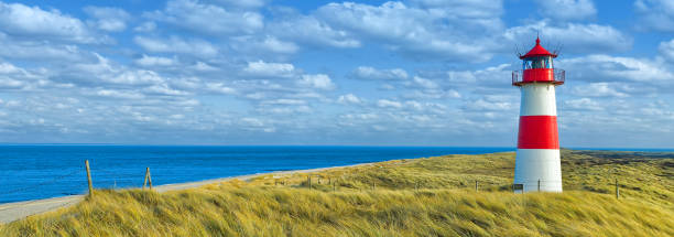 istock Red and white lighthouse with moody sky at Ellenbogen on island Sylt, Germany 956067032