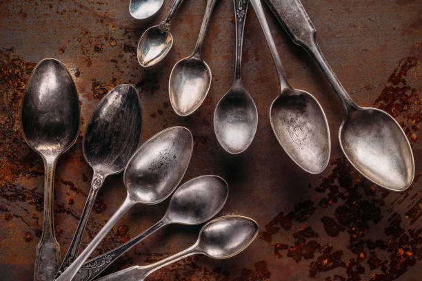 istock Old metal spoons on rusted background 956071510