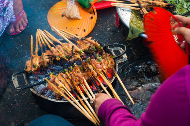 Skewered grilled meat, a popular local street food in Hoi An, Vietnam Hawker prepare the skewered grilled meats at street of Hoi An, a popular local street food of Vietnam hoi an stock pictures, royalty-free photos & images