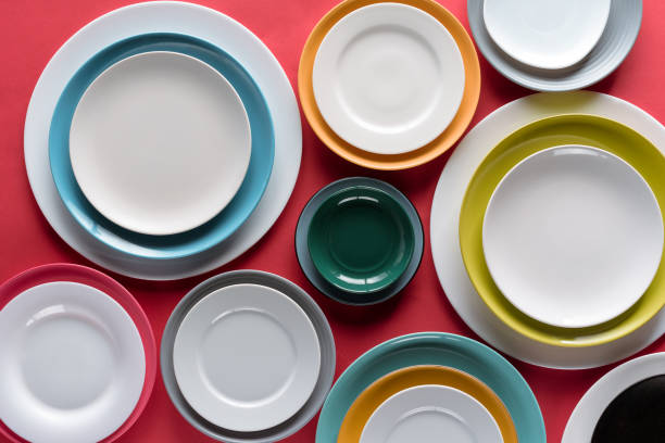 istock White and colorful plates of different sizes on red background 956075728