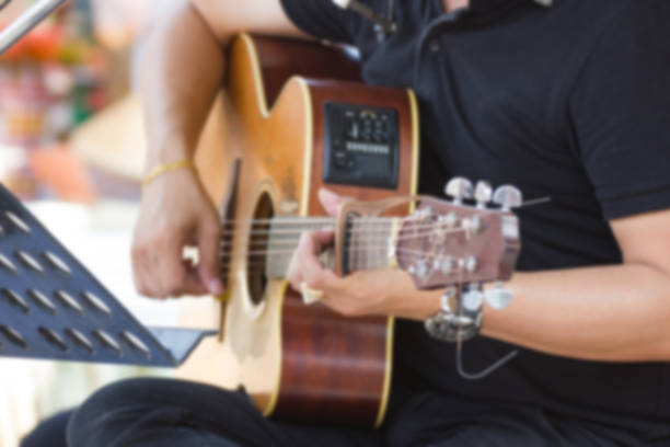 istock Blurred Image - Man Playing acoustic guitar in the room 956076990