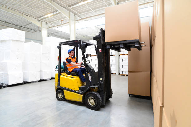 Workers in a warehouse - transport of goods with a forklift truck Workers in a warehouse - transport of goods with a forklift truck forklift photos stock pictures, royalty-free photos & images