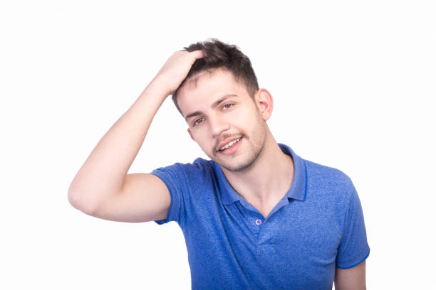 istock High angle view of relaxed young man looking at camera with content smile against white background 956078192