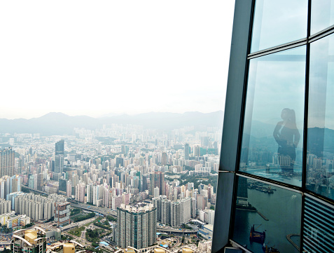 Businesswoman standing in a skyscraper building viewing over the city.