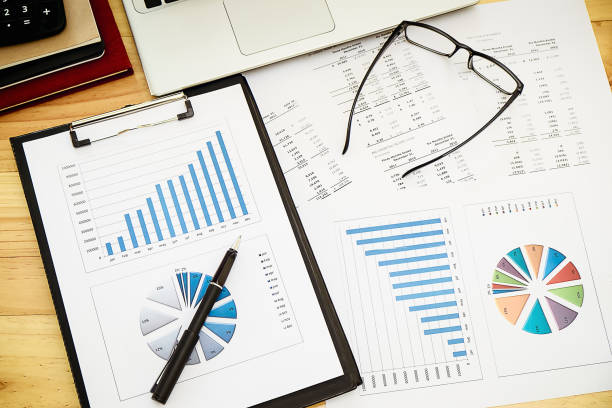 istock business concept : financial graph and chart report with pen, graph with notebook, glasses and calculator on desk of financial advisor. 956085638