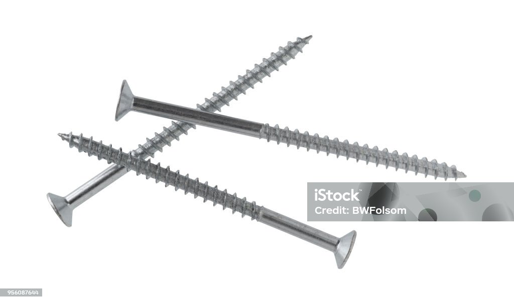 Long metal shelving screws on a white background. Top view of three long shelving screws isolated on a white background. Screw Stock Photo