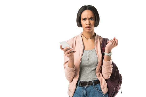 istock confused african american student with backpack using smartphone,  isolated on white 956093820