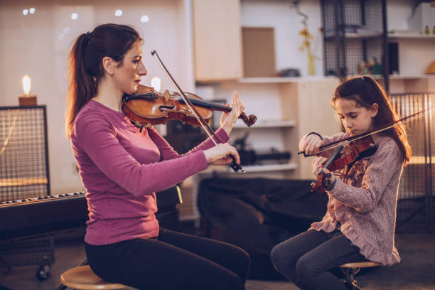 istock Girls playing violins 956095060