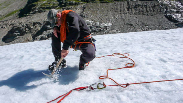istock one male mountain guide installing a pulley system for crevasse rescue on a glacier 956099446