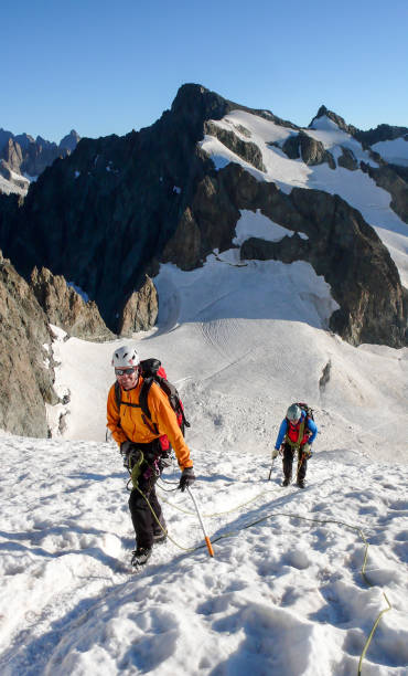istock mountain guide and client heading up a glacier towards a high alpine summit on a beautiful summer morning 956099482