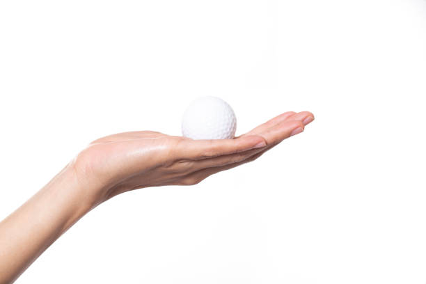 istock Golf ball in woman hand isolated on white background 956100758