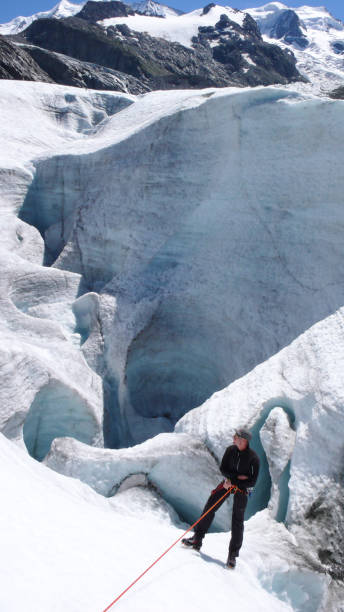 mountain climber hanging on a rope on a glacier during a rescue exercise