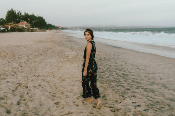 istock Woman  resting  on the beach in Mui Ne   at sunset 956109014