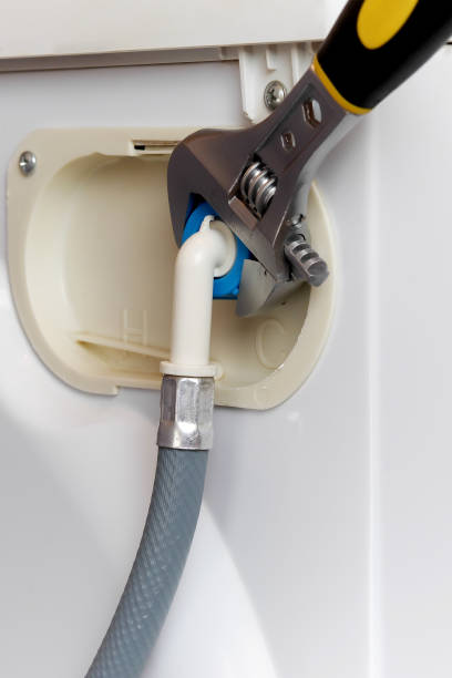 istock connecting water supply hose to washing machine using adjustable wrench 956109124