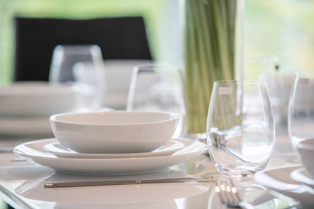 istock White bowl, plates and wine glasses on a table 956109292
