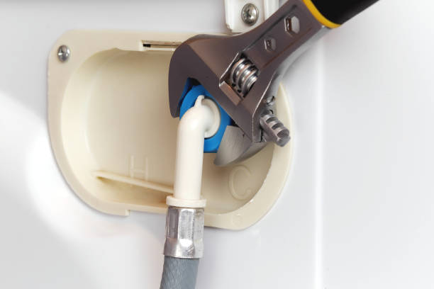 istock connecting water supply hose to washing machine using adjustable wrench 956109818