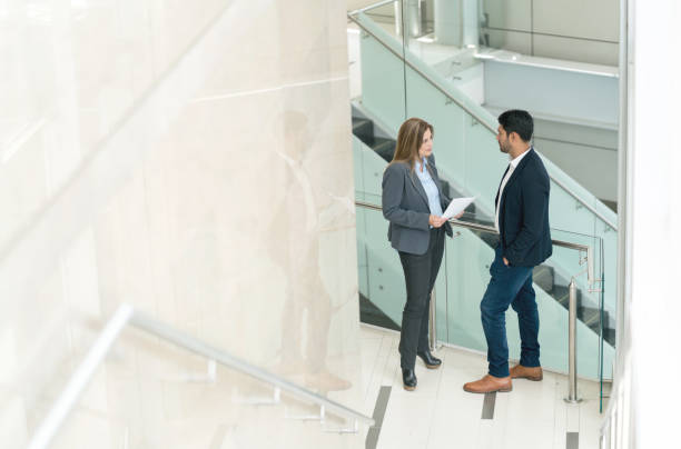 istock Female leader talking with a businessman very serious while holding some documents at a business center 956110546