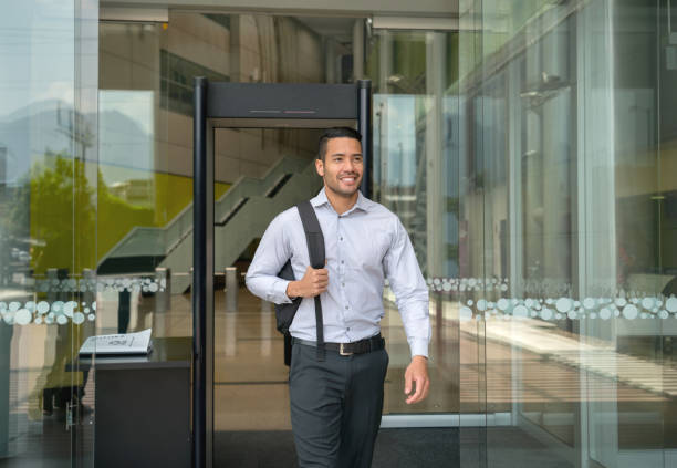 Handsome young businessman leaving a business center holding his backback very happy Handsome young businessman leaving a business center holding his backback very happy and smiling office leave stock pictures, royalty-free photos & images