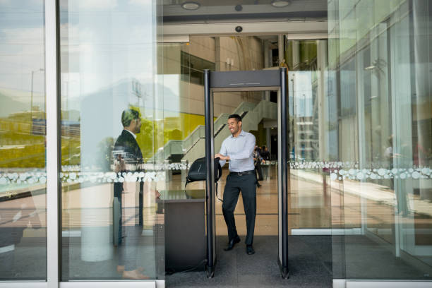 istock Business man leaving through the main entrance passing through the security check looking very happy 956110746