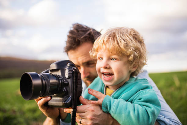 istock A father and his toddler son with a camera outside in spring nature. 956113870