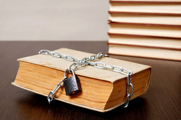 istock old book wrapped with chain and locked on padlock on table 956117574