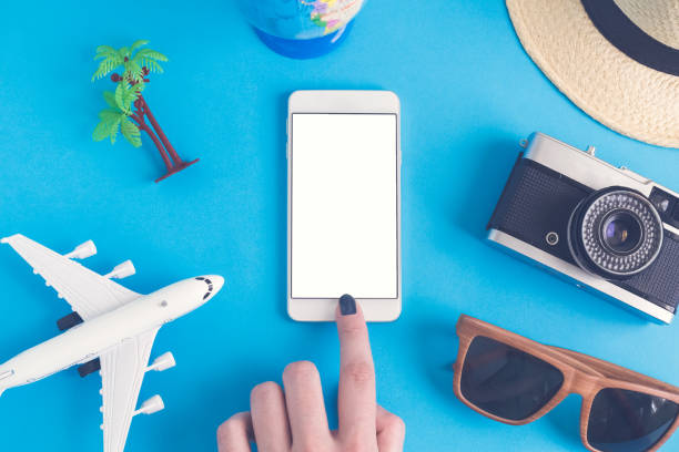 istock Flat lay of hand using smart phone and summer vacation items 956118174