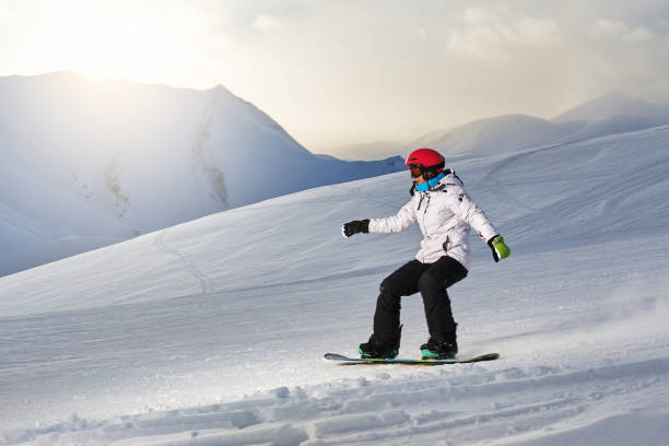 istock Girl snowboarder rides down  slope 956119252