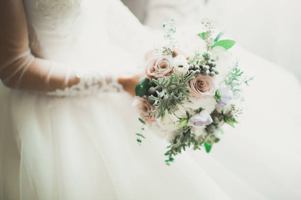 istock Bride holding big and beautiful wedding bouquet with flowers 956119538