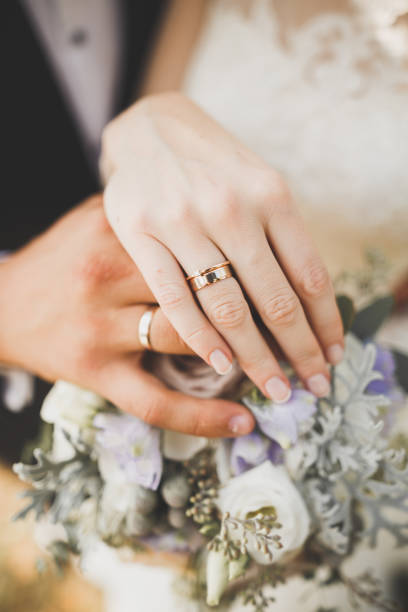 istock Newly wed couple's hands with wedding rings 956119920