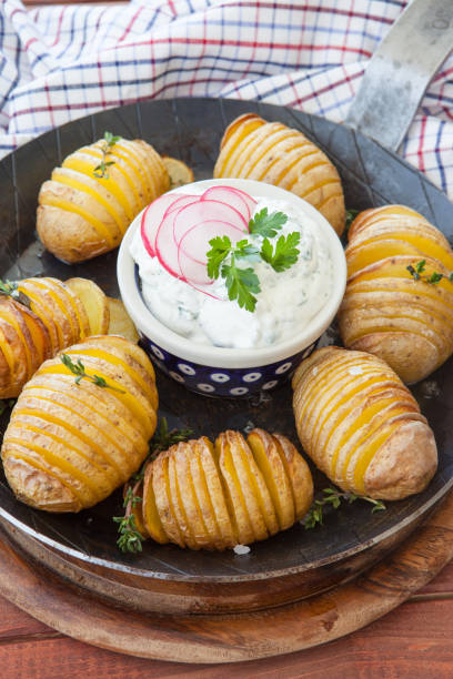 Rustic hasselback potatoes Rustic hasselback potatoes with fresh thyme and sea salt baked potato sour cream stock pictures, royalty-free photos & images