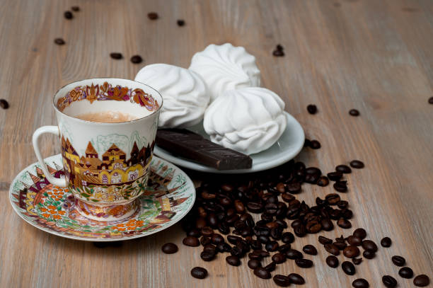 istock bright cup with coffee beans and sweets on a wooden table 956120730