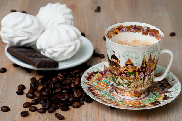 istock bright cup with coffee beans and sweets on a wooden table 956121720