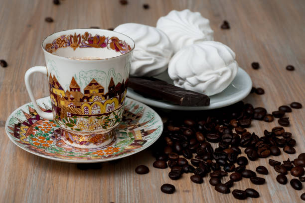 istock bright cup with coffee beans and sweets on a wooden table 956122398