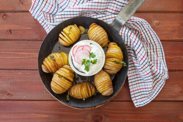 Rustic hasselback potatoes Rustic hasselback potatoes with fresh thyme and sea salt baked potato sour cream stock pictures, royalty-free photos & images