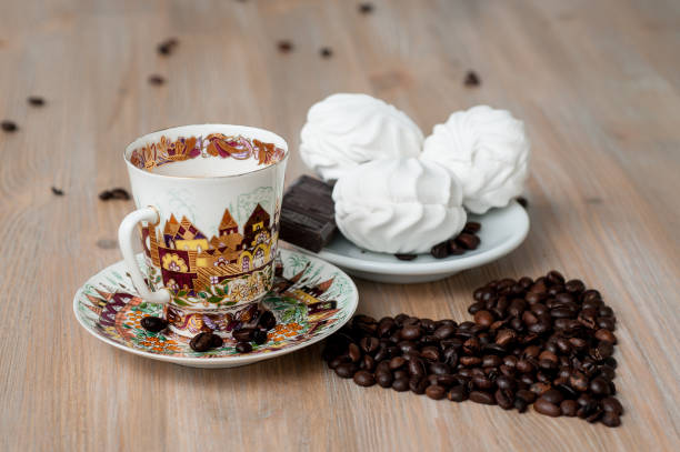 istock bright cup with coffee beans and sweets on a wooden table 956123016