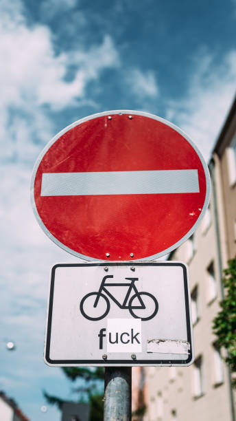 interesting road sign. street sign directing traffic along a one way street, with the exception of cyclists. - one way sign single object street imagens e fotografias de stock