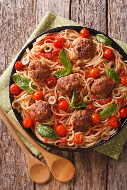 istock Italian food: spaghetti with meatballs and tomato sauce closeup on a plate. Vertical top view 956127854