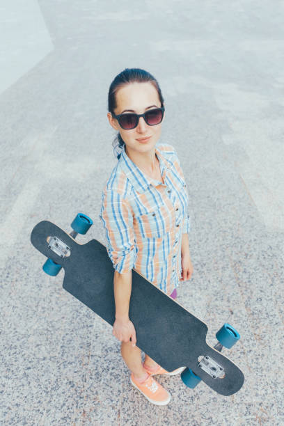 istock Street style girl with longboard. 956136912
