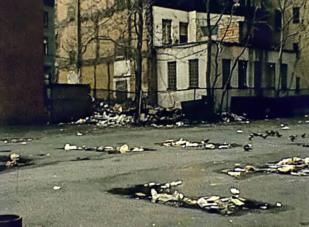 Old Manhattan alley with garbage on the dirty street in old New York, United States of America in 1981. Archival USA on 80s.