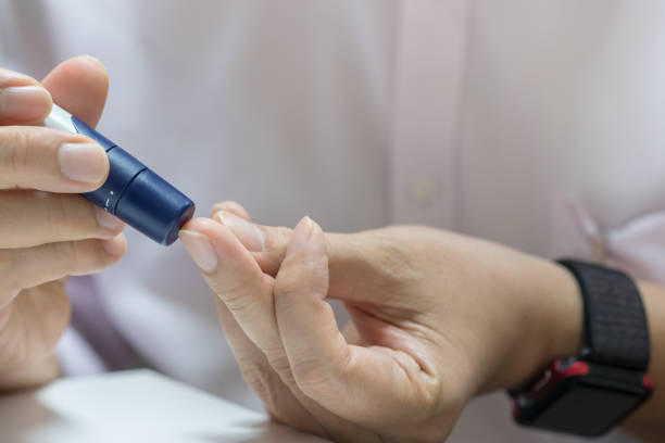 istock Close up of man hands using lancet on finger to check blood sugar level by Glucose meter using as Medicine, diabetes, glycemia, health care and people concept. 956143876