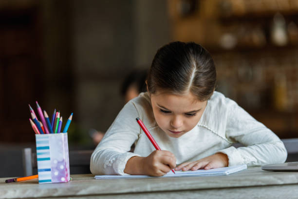 istock little child sitting at table and drawing in scrapbook at home 956146520