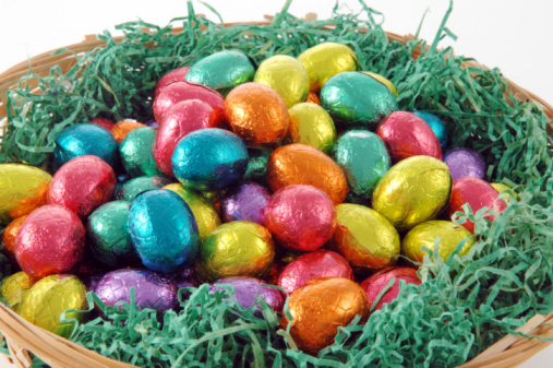 Easter chocolate eggs with candies on brown wooden table